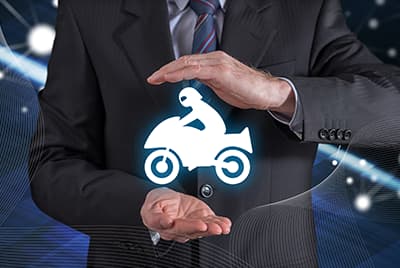 Un homme en costume qui entoure avec ses mains un dessin blanc d'une moto