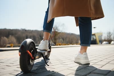 Femme circulant à trottinette électrique