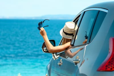 Une femme à la fenêtre de sa voiture en face de la mer