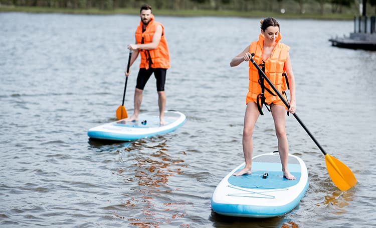 Un homme et une femme faisant du paddle sur une étendue d'eau