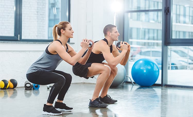 Une femme et un homme faisant des squats