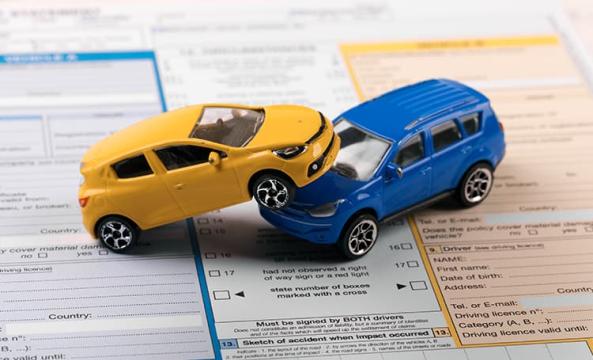 Deux voitures miniatures en collision posées sur un constat amiable