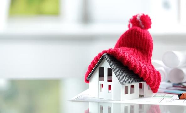 une maison en miniature recouverte par un bonnet rouge