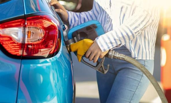Femme qui met de l'essence dans sa voiture à la station-service