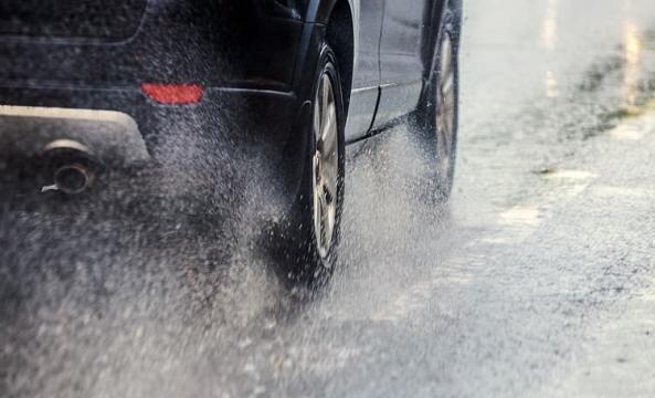 Voiture circulant en ville sous la pluie 