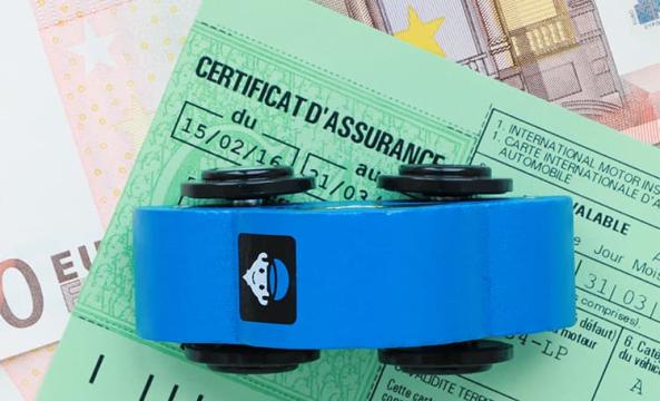 Une petite voiture bleue en bois posée sur un certificat d'assurance