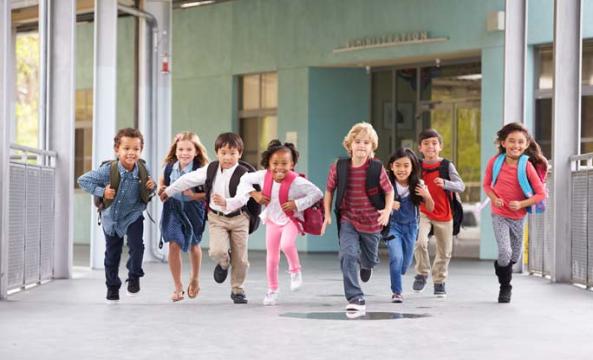 Un groupe d'enfants sortant en courant de l'école