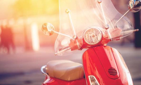 Un scooter rouge stationné sur la roue