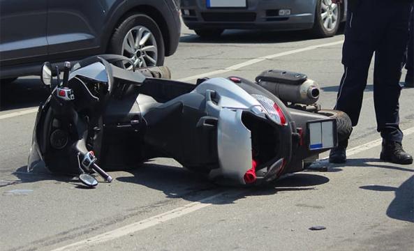 Un scooter accidenté couché sur la route