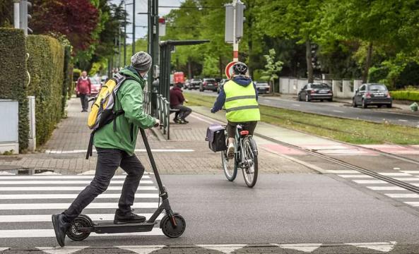 Une personne avec une veste verte sur une trottinette électrique