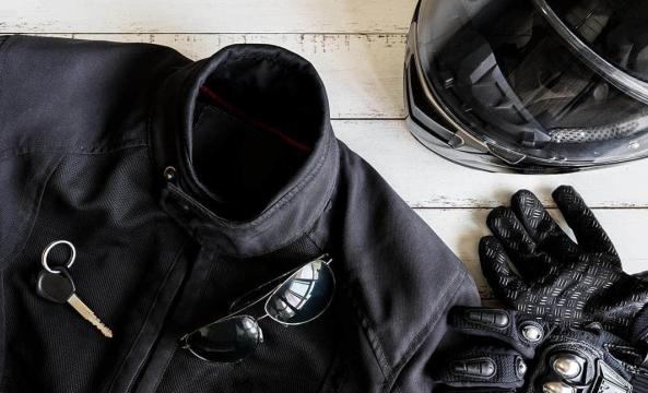 Un blouson de motard, des gants et un casque noirs vus de haut