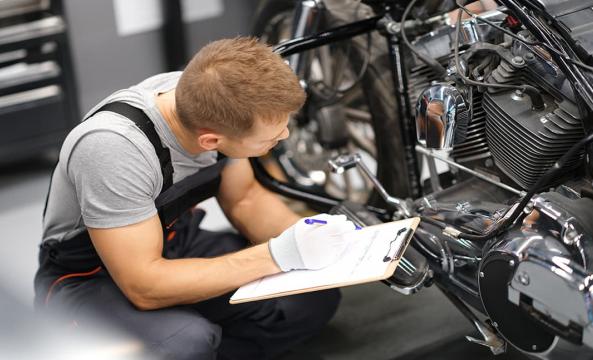 Un technicien analysant différents points de contrôle sur une moto
