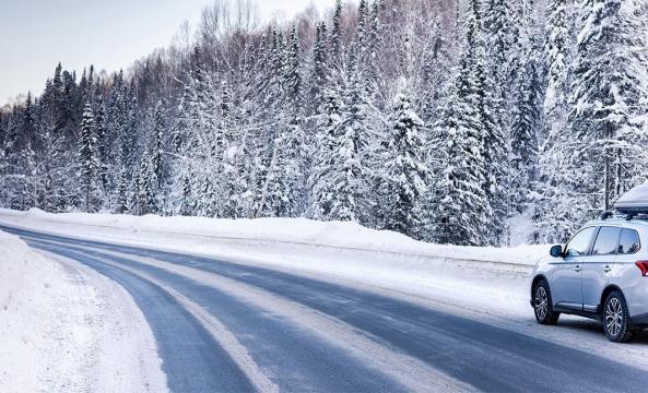 Une voiture blanche sur une route enneigee