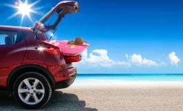 Voiture sur la plage, chargée de bagage pour la mer avec un beau soleil en fond