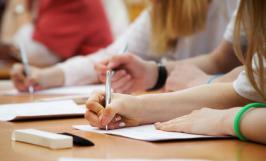 Une élève en train de prendre des notes avec un stylo 