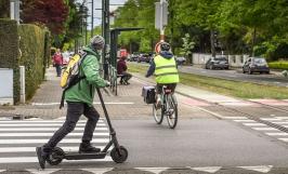 Une personne avec une veste verte sur une trottinette électrique