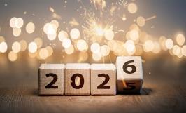 Des cubes en bois avec les chiffres 2026 devant des étincelles
