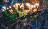 Famille qui accroche des guirlandes lumineuses de Noël sur sa maison