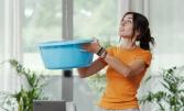 femme avec un seau d'eau suite à une fuite dans son appartement