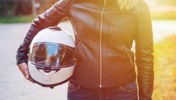 femme tenant casque de moto dans les mains 