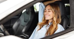 Jeune femme décontractée et souriante au volant de sa voiture