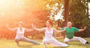 Trois personnes pratiquant le taï chi sur l'herbe