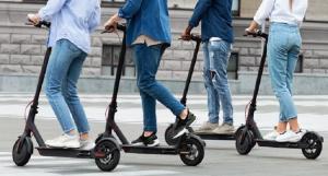 Quatre jeunes circulant en trottinettes électriques sur la route