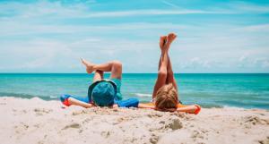 Deux enfants les pieds en l'air allongés sur la plage