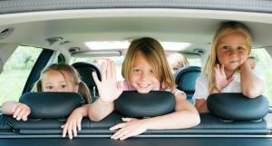 3 enfants souriants dans une voiture