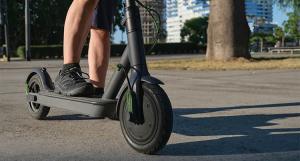Gros plan sur les jambes d'un homme sur sa trottinette électrique
