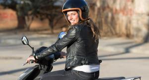 Une jeune femme en blouson en cuir sur un scooter