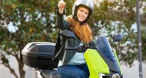 Une jeune femme sur un scooter noir et vert