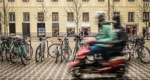 Des jeunes personnes floues sur un scooter rouge