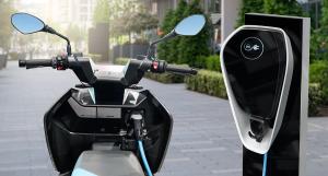 Un scooter électrique raccordé à une borne de recharge