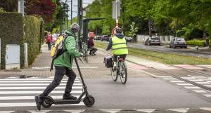 Une personne avec une veste verte sur une trottinette électrique