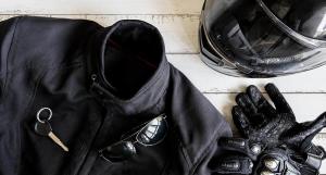 Un blouson de motard, des gants et un casque noirs vus de haut