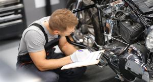 Un technicien analysant différents points de contrôle sur une moto